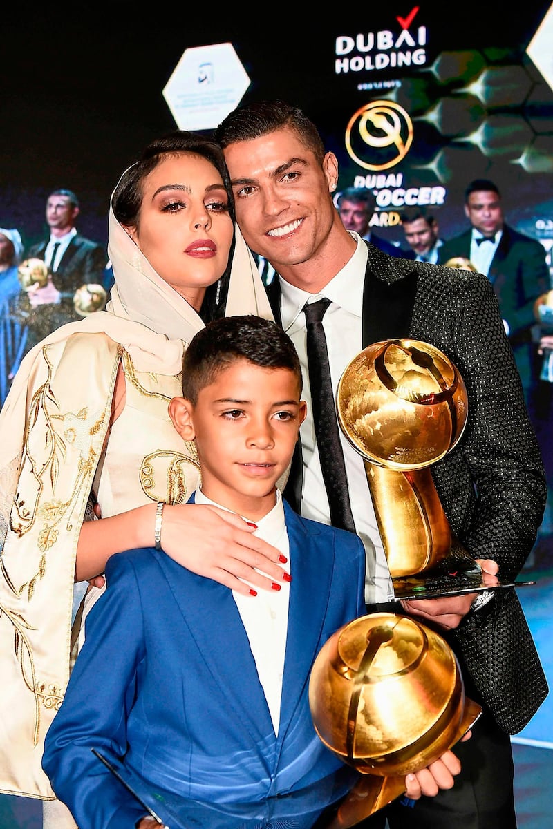 Juventus' Portuguese forward Cristiano Ronaldo (R), holding his "Best Player of the Year 2018 Award" poses his companion Georgina Rodriguez (L) and his son Cristiano Jr, holding his father's "433 Fans' Award", during the 10th edition of the Dubai Globe Soccer Awards in Dubai.  AFP