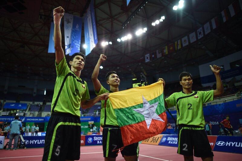 Latt Zaw, left, Lin Aung Wai, centre, and Zaw Aung Zaw, right, of Myanmar celebrate their win over South Korea in the Sepaktakraw men's doubles final at the Asian Games. Ed Jones / AFP