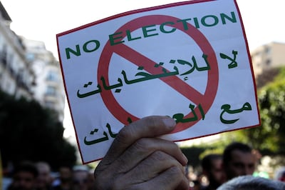 People demonstrate with anti-election posters in Algiers, Friday, Dec. 6, 2019. Algeria's 9-month-old mass movement believes the presidential Dec.12 poll is a sham and fear it will be rigged in favor of the old regime. (AP Photo/Fateh Guidoum)