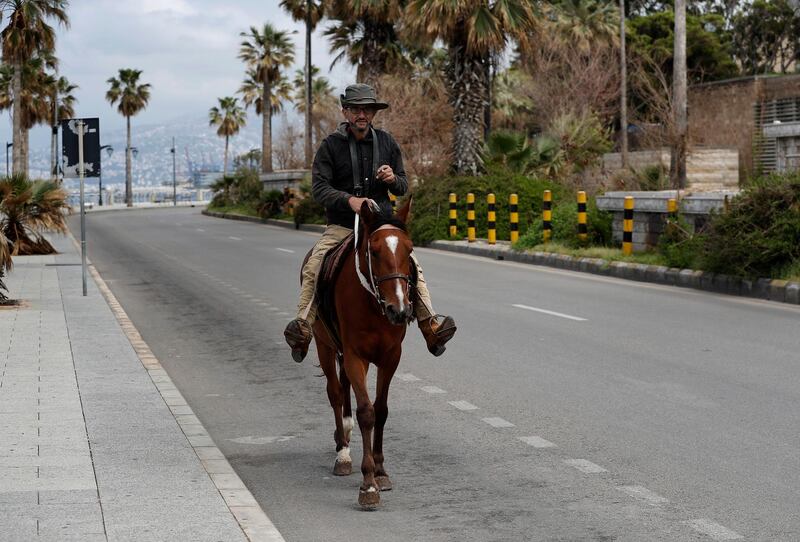 Abu-Hattab rides his horse on a deserted street after security forces began implementing strict measures that allow vehicles with even or odd plate numbers to drive for three days a week each and Sundays will be banned for all driving, as part of a plan to help stem the spread of the coronavirus, in Beirut, Lebanon. AP Photo