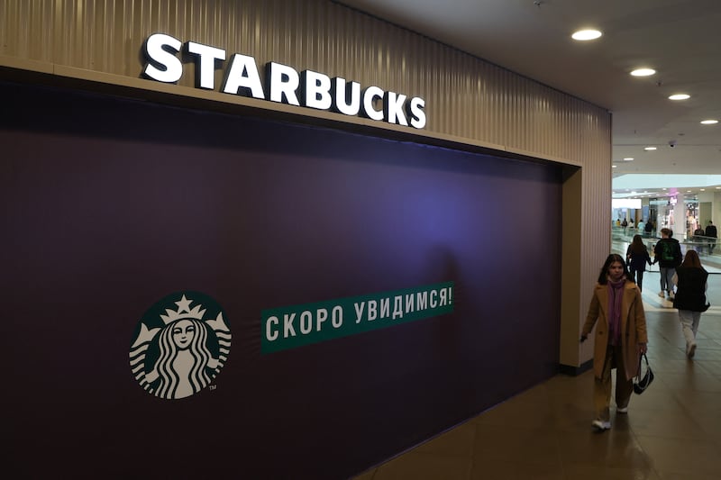 A woman walks past a closed Starbucks cafe in central St Petersburg, Russia, on May 23, 2022. Reuters