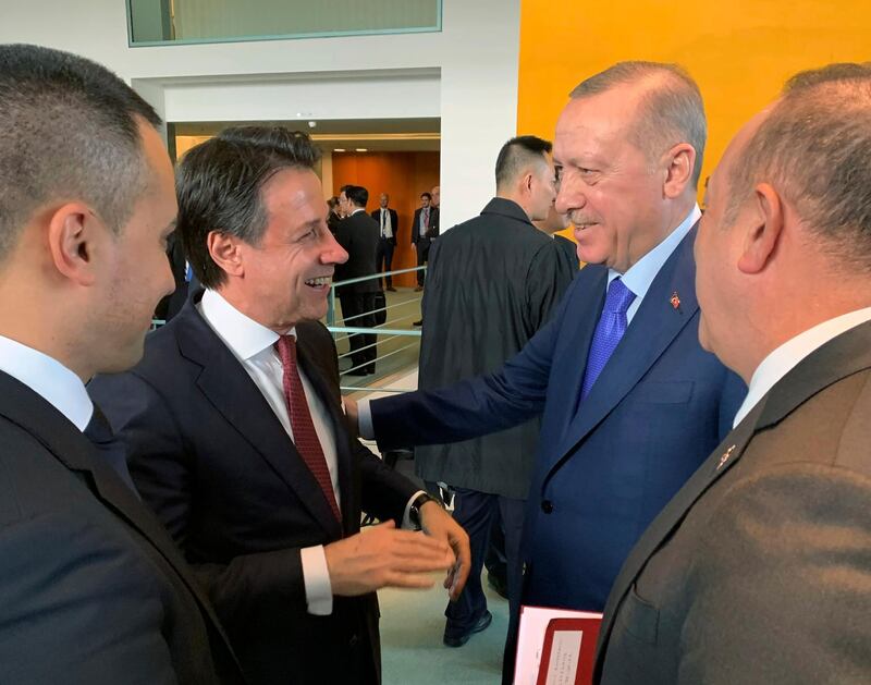 Turkish President Recep Tayyip Erdogan, right, and Italian Prime Minister Giuseppe Conte speak on the sideline of the conference on Libya at the Chancellery in Berlin, Sunday, Jan. 19, 2020. German Chancellor Angela Merkel hosts the one-day conference of world powers in Berlin to discuss efforts to broker peace in Libya.(Turkish Presidency Press Service via AP, Pool)