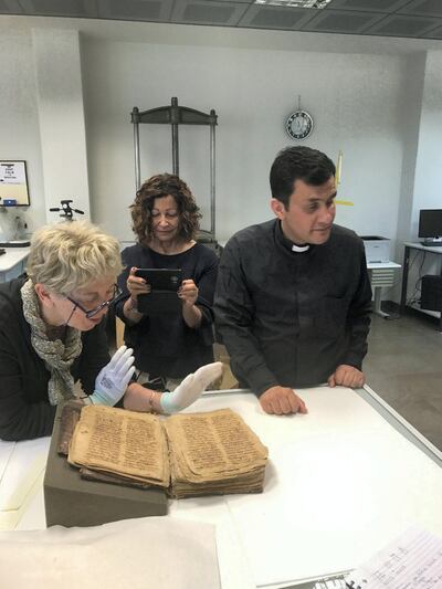 Father Ammar Altony Yako  with the historic Aramaic prayer manuscript. Courtesy Father Ammar Altony Yako