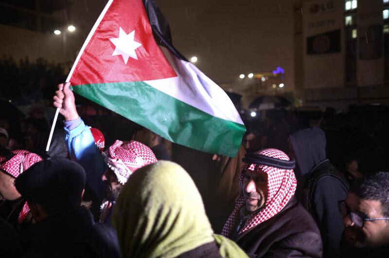 epa07213194 Jordanians hold their national flags and shout slogans as they demand the government for reforms in various fields during a protest under a heavy rain, in Amman, Jordan, 06 December 2018. A few hundred protesters gathered in the area leading to the Prime Minister office in central Amman, to demand political and economic reforms. The last time such protests took place, earlier in the summer, they had led to a change of government.  EPA/ANDRE PAIN