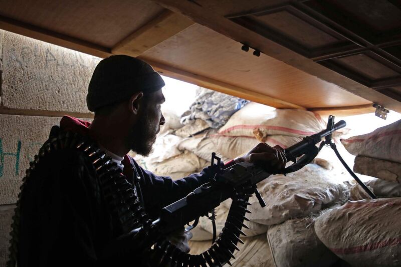 A Syrian rebel-fighter from the National Liberation Front (NLF) holds a machine gun at a position fortified with sandbags near the frontline in the rebel-held al-Rashidin district of western Aleppo's countryside near Idlib province, on November 26, 2018. Air strikes hit the edges of Syria's last major rebel stronghold west of Aleppo on November 25, the Britain-based Syrian Observatory for Human Rights monitor said a day after an alleged toxic attack on the regime-held city. The SOHR said regime ally Russia "likely" carried out the air strikes on a planned buffer zone around the opposition bastion of Idlib, the first to hit the area since Moscow and rebel backer Ankara agreed to set up a demilitarised area around Idlib to prevent a massive regime attack to retake the area. / AFP / Aaref WATAD
