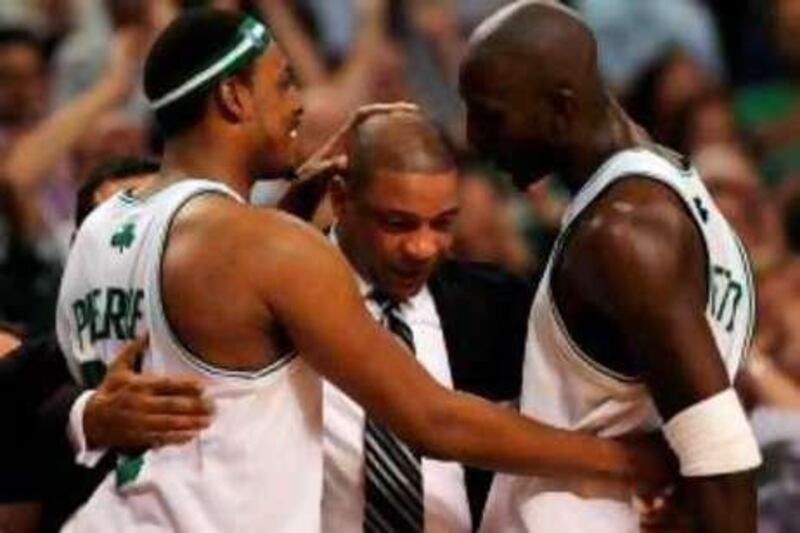Boston Celtics' Paul Pierce (L) and Kevin Garnett (R) hug head coach Doc Rivers (C) after winning Game 6 of the 2008 NBA Finals in Boston, Massachusetts, June 17, 2008. The Boston Celtics captured the National Basketball Association championship, routing the Los Angeles Lakers 131-92 to win the best-of-seven NBA Finals four games to two. AFP PHOTO / GABRIEL BOUYS *** Local Caption ***  717326-01-08.jpg