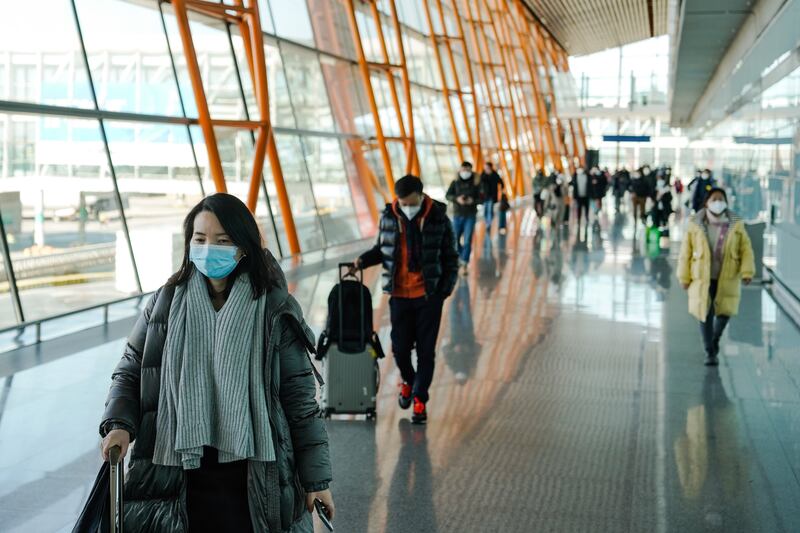 Passengers get set to board flights in Beijing. EPA 