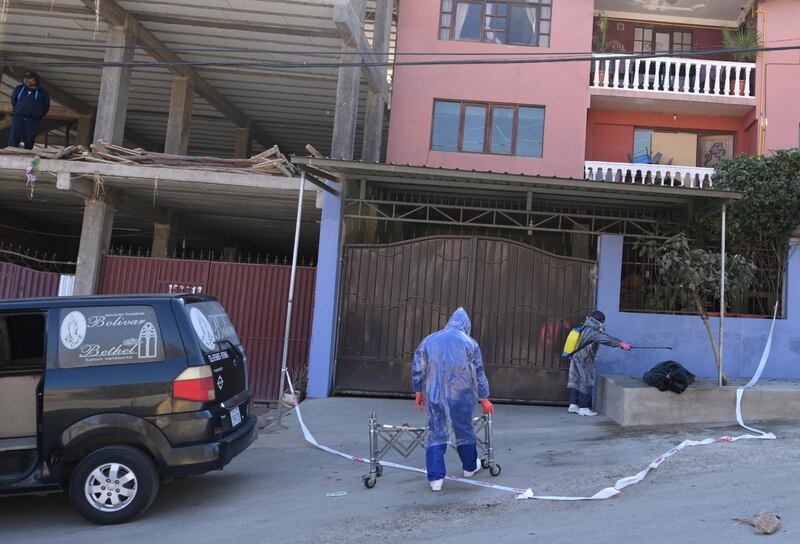 An employee of a funeral home disinfects a bag containing the body of a man who died on a street in Cochabamba, Bolivia. Reuters