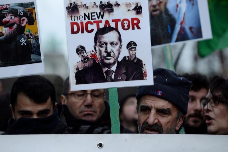 A protester holds a banner depicting Turkish President Erdogan during a demonstration against a visit of the president in Brussels.  Reuters