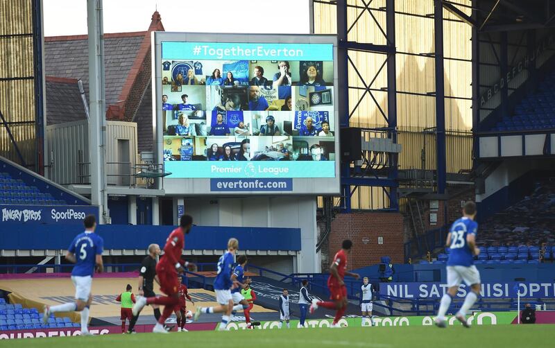 Everton fans are seen on a large screen as they watch remotely the English Premier League soccer match between Everton and Liverpool at Goodison Park in Liverpool, England. AP