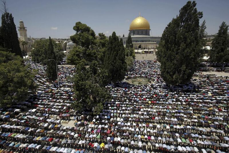 Palestinian worshippers pray in front of the Al-Aqsa Mosque in Jerusalem during the first Friday of the holy month of Ramadan. The golden Dome of the Rock shrine is seen in the background. Mahmoud Illean / AP photo