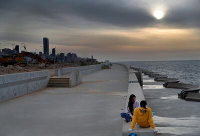 A couple sit at a waterfront promenade, along the Mediterranean Sea, which is almost empty of residents during a lockdown that imposed by the government to help stem the spread of the coronavirus, in Beirut, Lebanon, Saturday, April 4, 2020. The virus causes mild or moderate symptoms for most people, but for some, especially older adults and people with existing health problems, it can cause more severe illness or death. (AP Photo/Hussein Malla)