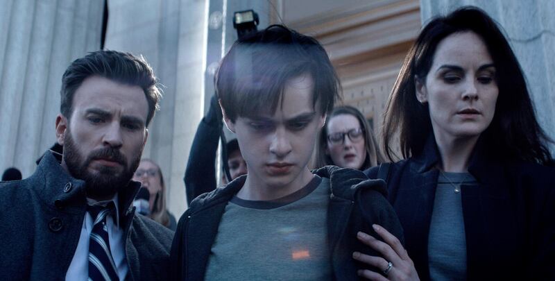 This image released by Apple TV Plus shows Chris Evans, from left, Jaeden Martell and Michelle Dockery in a scene from "Defending Jacob." The six-part Apple TV Plus drama series adapted from the 2012 New York Times best-selling novel by William Landay, premieres April 24. (Apple TV Plus via AP)