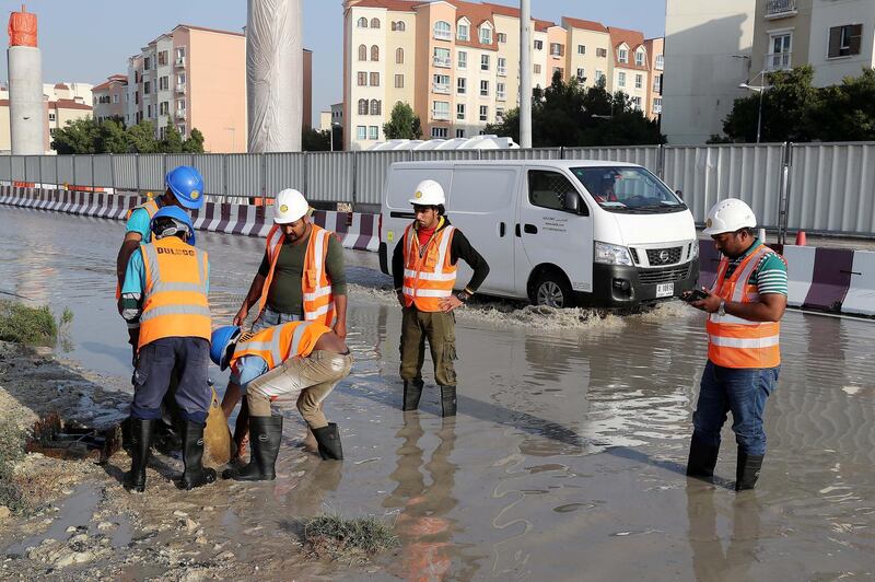 DUBAI , UNITED ARAB EMIRATES , JAN 09 – 2018 :- Workers at the under construction Dubai Metro site clearing the blocked drainage because of last night rain in Discovery Gardens area in Dubai.  (Pawan Singh / The National) For News. 