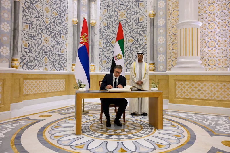 Mr Vucic signs the visitors book.

