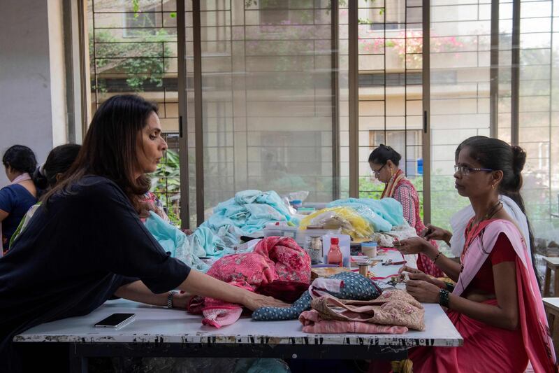 In this photo taken on February 14, 2020, fashion designer Anita Dongre (L) interacts with a worker at her factory on the outskirts of Mumbai. With stores in India and New York, multiple clothing brands and a global celebrity following, fashion designer Anita Dongre is a feminist powerhouse in a male-dominated industry. But her true ambition is to create an environmentally sustainable company, she says. - TO GO WITH Women-activism-India-fashion-economy-environment,INTERVIEW by Ammu Kannampilly
 / AFP / Laurène Becquart / TO GO WITH Women-activism-India-fashion-economy-environment,INTERVIEW by Ammu Kannampilly

