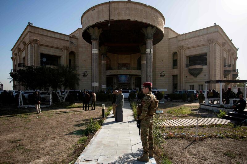 Member of the Hashed Shaabi stand outside a building at the Presidential Palace compound in Basra, during a funeral of Dagher Mussawi, a leader in the Hashed.   AFP