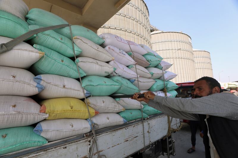 Workers collect wheat at the Banha silos. 