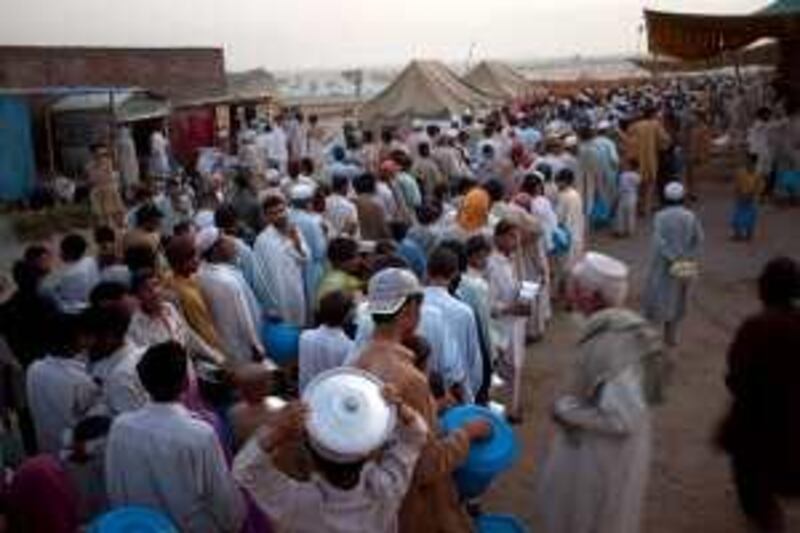 Displaced Pakistani men line up as they wait for donated food during a distribution at the Chota Lahore refugee camp, at Swabi, in northwest Pakistan, Thursday, May 21, 2009.  Donations to help refugees fleeing Pakistan's latest offensive against the Taliban surpassed $200 million Thursday, as the country's allies sought to ease a crisis that risks eroding public support for military action against the militants.   (AP Photo/Emilio Morenatti)  *** Local Caption ***  JEM109_Pakistan_.jpg
