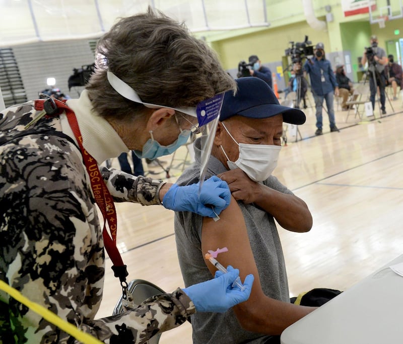 Kathi Carlsten, a Los Angeles Unified School District nurse, applies a dose of the Moderna vaccine to a LAUSD employee as LAUSD's first vaccination site opened at the Roybal Learning Center, in Los Angeles. Superintendent Austin Beutner was there in the morning to meet with the vaccination team and the first district employees to receive their vaccines at this site. AP Photo