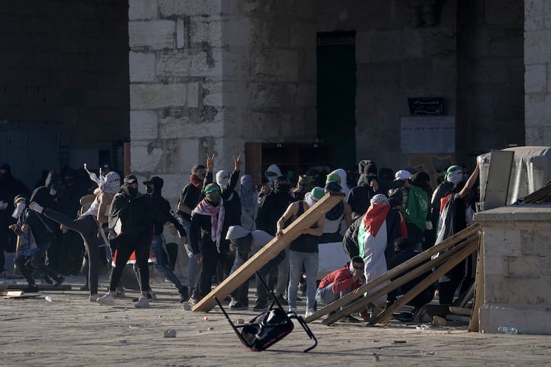 Worshippers set up barricades outside the mosque during the violence. AP