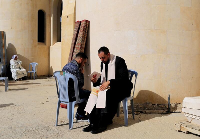 A Catholic priest takes a faithful's confession before the start of the mass start outside the Latin Church during the Jordan Catholic church annual pilgrimage, at the Baptism Site, Jordan Valley, some 60km Southwest of Amman, Jordan. Thousands of Jordanian Catholics headed to the place believed to be where John baptized Jesus Christ in the water of the Jordan River.  EPA