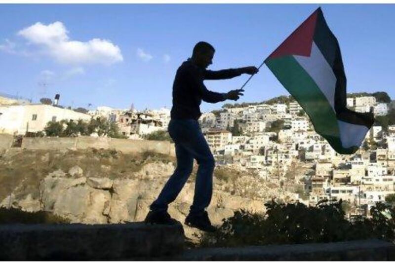 The Palestinian flag is held up as Israeli, Palestinian and foreign activists hold a demonstration in the Arab east Jerusalem neighbourhood of Silwan against Jewish settlement activity in the Palestinian districts of the city. Ahmad Gharabli / AFP Photo