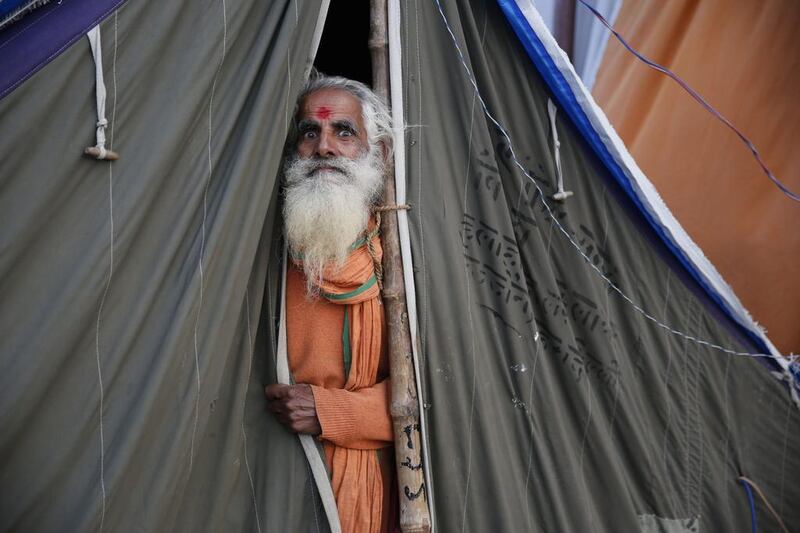 A Hindu holy man peeps from his tent on January 27, 2014, at Sangam, the confluence of the Ganges and Yamuna rivers, during the annual Magh Mela fair in Allahabad, India. Hundreds of thousands of devout Hindus are expected to take holy dips at the confluence during this astronomically auspicious 45-day period. Rajesh Kumar Singh / AP photo