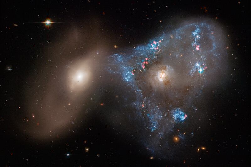 An image of two galaxies colliding, fuelled an unusual triangular-shaped star-birthing. Captured by the Hubble telescope in 2022, the interacting galaxies are called Arp 143. Photo: Nasa