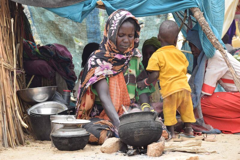 A Sudanese refugee who crossed into Chad cooks a meal in a makeshift shelter at a camp in Koufroun, near Echbara, on May 1. AFP