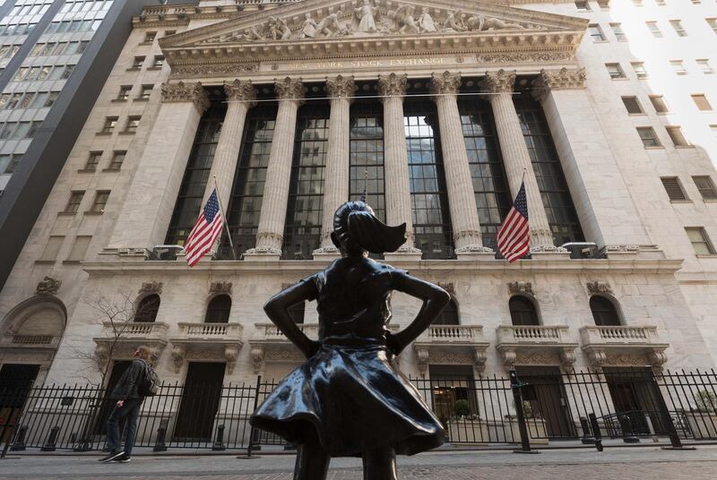 The New York Stock Exchange (NYSE) at Wall Street and the  'Fearless Girl' statue are seen on March 23, 2021 in New York City. - Wall Street stocks were under pressure early ahead of congressional testimony from Federal Reserve Chief Jerome Powell as US Treasury bond yields continued to retreat. (Photo by Angela Weiss / AFP)