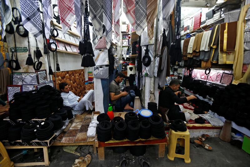 Men make igals, traditional Arabic cords worn on heads, at a store in a market in Najaf, Iraq. Reuters