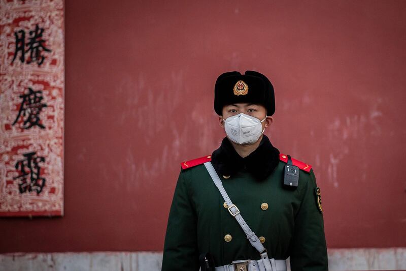 A paramilitary police officer wearing a protective facemask to help stop the spread of a deadly SARS-like virus, which originated in the central city of Wuhan, stands guard at the exit of the Forbidden City in Beijing.  AFP