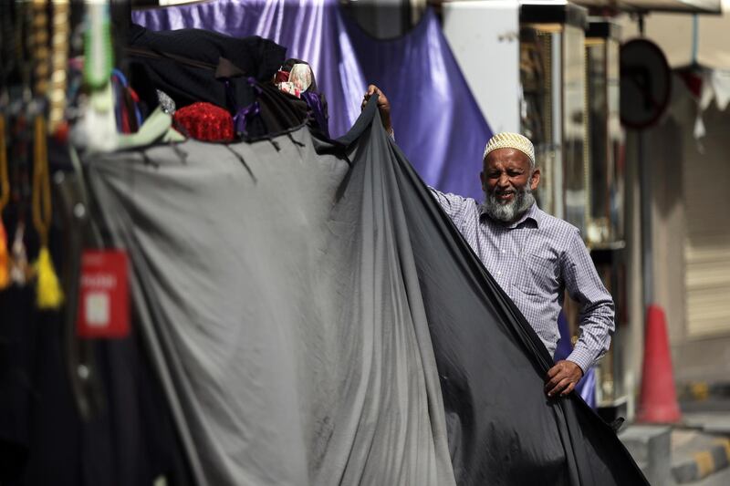 A man closes his shop in a street of Manama. EPA