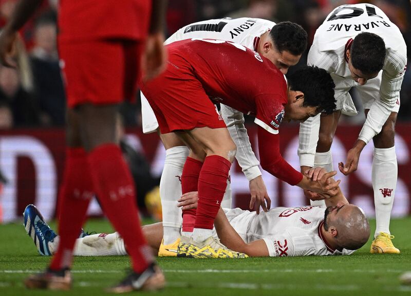 Liverpool's Wataru Endo helps Manchester United's Sofyan Amrabat to his feet after fouling him. AFP