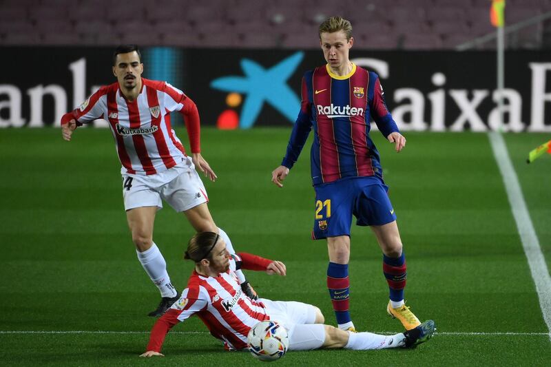 Athletic Bilbao's Spanish forward Iker Muniain (C) challenges Barcelona's Dutch midfielder Frenkie De Jong during the Spanish league football match FC Barcelona against Athletic Club Bilbao at the Camp Nou stadium in Barcelona on January 31, 2021. (Photo by LLUIS GENE / AFP)