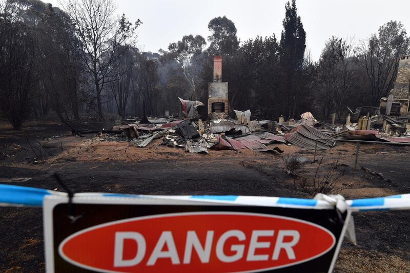 A woodchip mill burnt by bushfires is seen as smoke rises in Eden, NSW, Australia. AFP