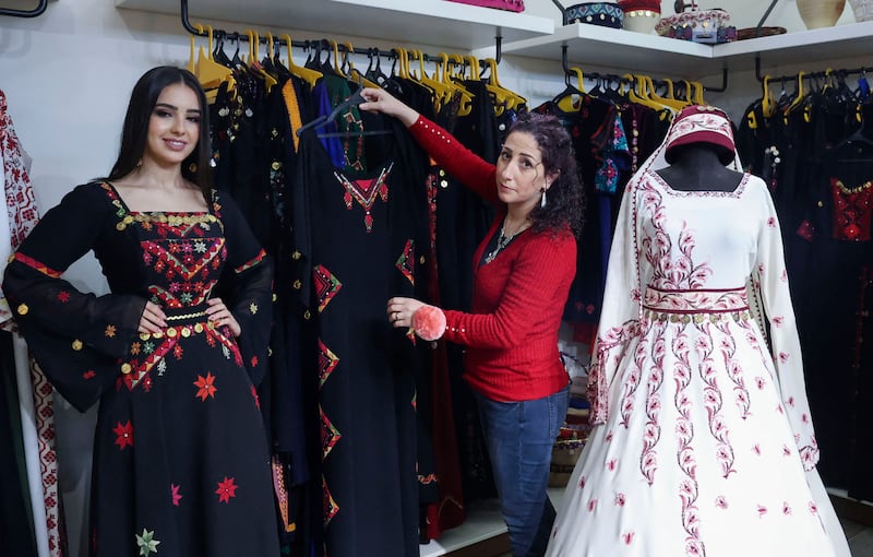 The designer dresses a woman in a traditional Palestinian dress.