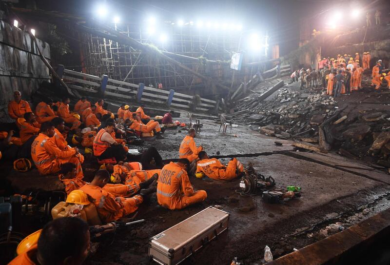 Rescue personnel take a break before continuing their duties. AFP