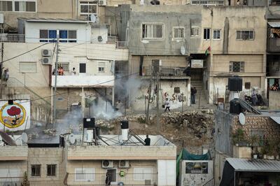 Palestinians run from tear gas fired by Israeli police during clashes in the Silwan neighborhood of east Jerusalem, Friday, June 4, 2021. Clashes erupted after a marathon by activists in solidarity with residents of two Palestinian neighborhoods under threat of forced expulsions by Israeli settlers. (AP Photo/Maya Alleruzzo)