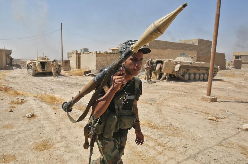 A fighter from the Hashed Al-Shaabi (Popular Mobilization units) carries his RPG inside al-Nour neighbourhood, in eastern Tal Afar, the main remaining stronghold of the Islamic State group, after the government announced the beginning of an operation to retake it from the jihadists, on August 23, 2017. - Iraqi forces recaptured several districts and advanced towards the centre of Tal Afar, one of the Islamic State group's last strongholds in the country, as aid workers braced for an exodus of civilians fleeing the fighting. (Photo by AHMAD AL-RUBAYE / AFP)