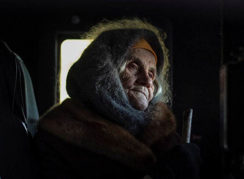 Oleksandra Koshkina, 85, sits in a car as she returns to her village of Torske, in the Donetsk enclave. Reuters