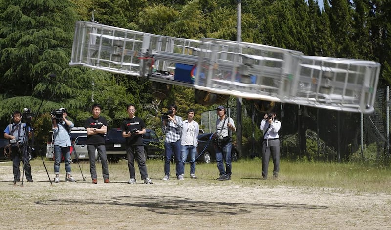 Tsubasa Nakamura, project leader of Cartivator, third from left, watches the flight of the test model of the flying car on a former school ground in Toyota, central Japan, Saturday, June 3, 2017. (AP Photo/Koji Ueda)