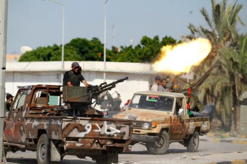 A Libyan rebel fighter fires from the back of his vehicle towards Bab al Aziziya compound in Tripoli August 23, 2011. REUTERS/Zohra Bensemra (LIBYA - Tags: POLITICS CIVIL UNREST MILITARY) *** Local Caption ***  ZOH01_LIBYA-_0823_11.JPG