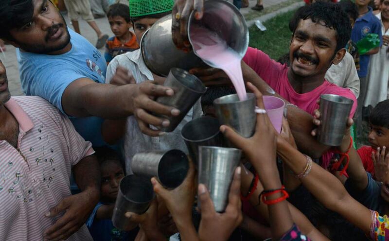 Pakistani Muslim devotees receive a sweet drink to break their fast during the Muslim fasting month of Ramadan in Lahore on June 19, 2015. Islam’s holy month of Ramadan is celebrated by Muslims worldwide. Arif Ali / AFP photo