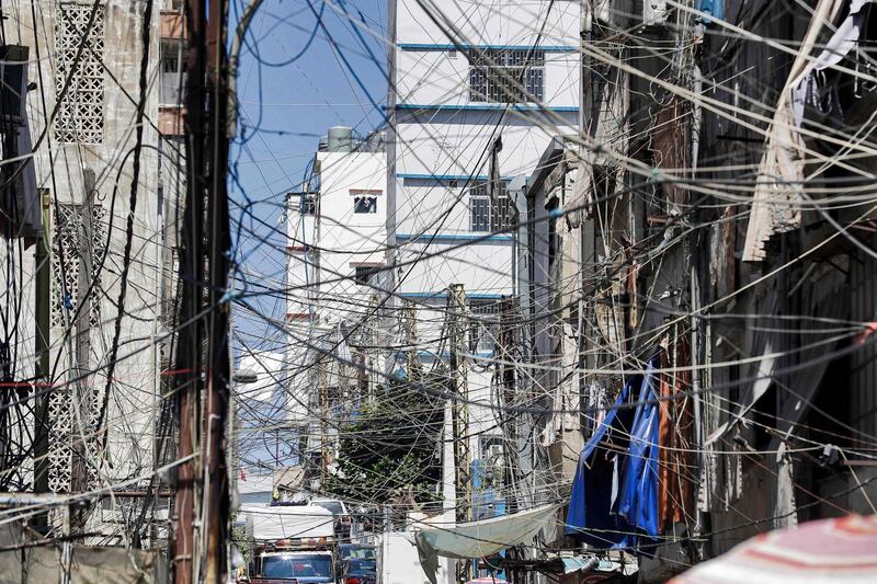This picture taken on June 23, 2021 shows a view of a mesh of raised electricity lines along a street in a suburb of Lebanon's capital Beirut. The owners of private generators that provide a vital backup to Lebanon's decrepit power grid warned of their own power cuts due to lack of fuel as the country's economic crisis deepens. The national network run by Electricité du Liban is prone to blackouts and in some areas only manages to provide power for two hours a day. That forces many Lebanese to pay a separate bill for a backup from neighbourhood generators run by private firms. / AFP / JOSEPH EID
