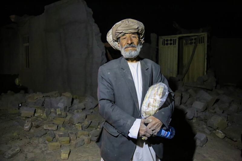 An Afghan survivor stands outside his collapsed house near Herat. EPA