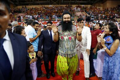 FILE- In this Oct. 5, 2016 file photo, Indian spiritual guru who calls himself Saint Dr. Gurmeet Ram Rahim Singh Ji Insan, center, greets followers as he arrives for a press conference ahead of the release of his new movie "MSG, The Warrior Lion Heart," in New Delhi, India. Several cities in north India were under a security lock down Thursday ahead of a verdict in a rape trial involving a controversial and hugely popular spiritual leader. (AP Photo/Tsering Topgyal, File)