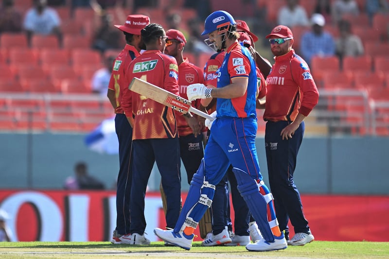 Delhi Capitals' Mitchell Marsh walks back to the pavilion after his dismissal, caught by Rahul Chahar off the bowling of Arshdeep Singh for 20 runs. AFP