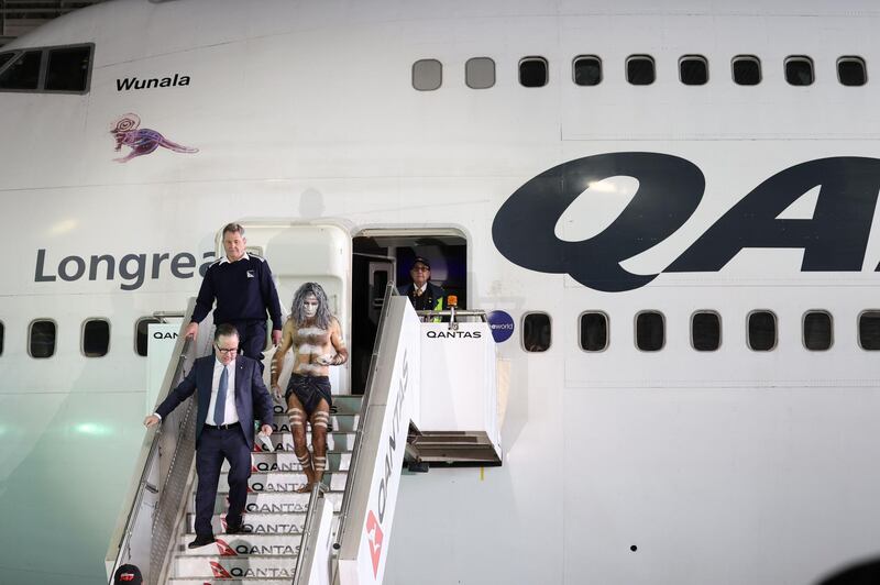 Alan Joyce and an indigenous Australian come down from a Qantas 747 jumbo jet. Reuters